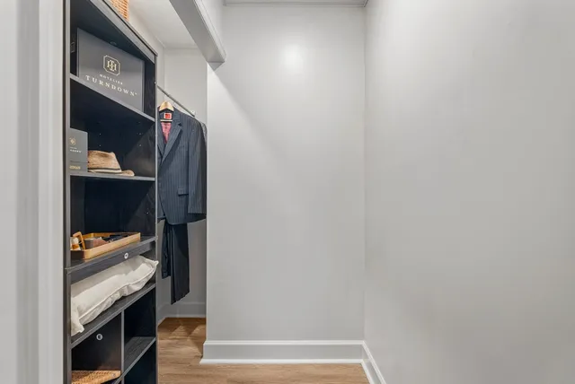 a view of walk in closet with clothes and shoes
