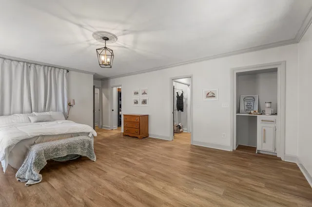 a spacious bedroom with a bed and a chandelier