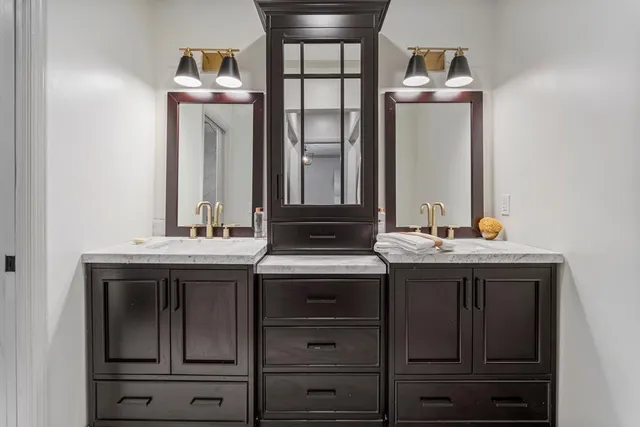 a bathroom with a granite countertop sink and a mirror