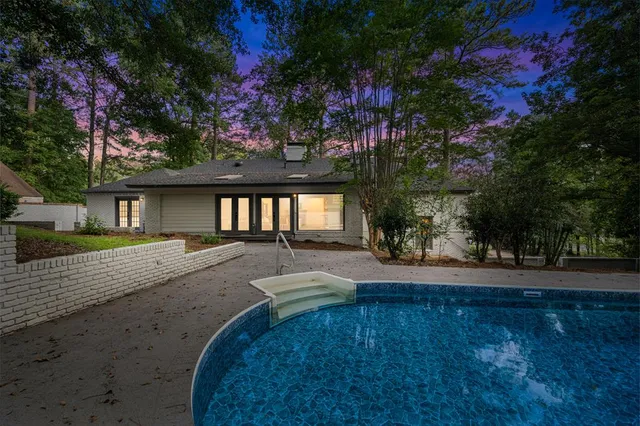 a view of a house with a large window and wooden fence
