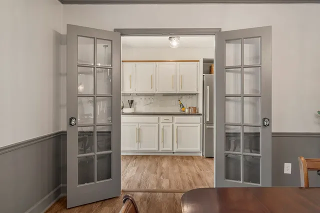a kitchen with a refrigerator and white cabinets