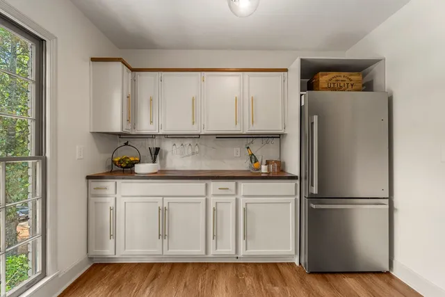 a kitchen with white cabinets and refrigerator