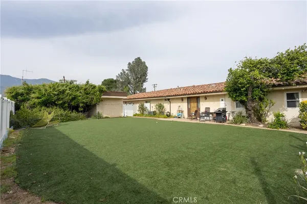 an aerial view of a house with a yard wooden table and chairs