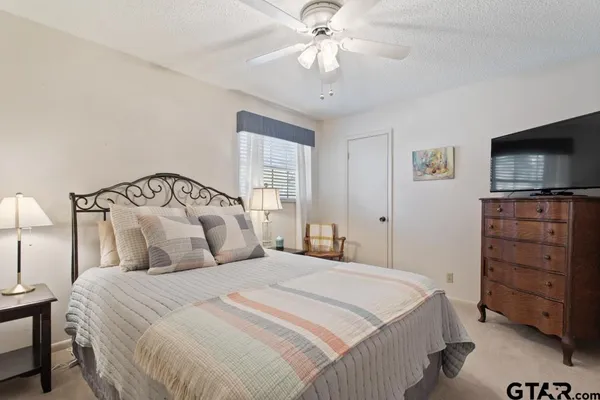 a bedroom with a bed and a flat tv screen on dresser