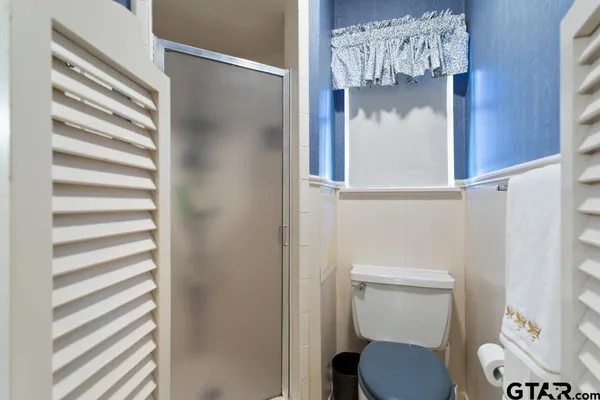 a white toilet sitting next to a shower curtain