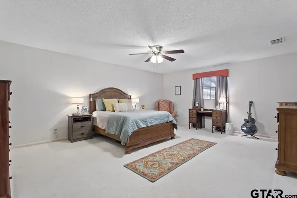 a bedroom with a large bed lamps and a dresser