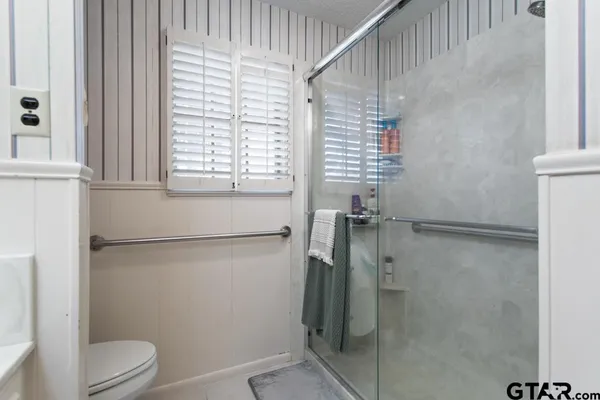 a bathroom with a shower a toilet and a window