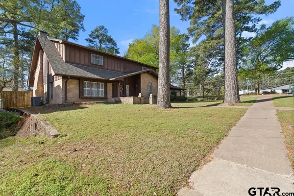 a front view of a house with a yard and trees