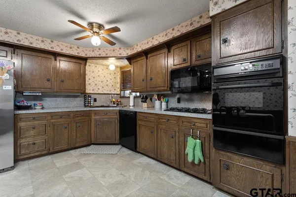 a kitchen with granite countertop stainless steel appliances and wooden cabinets