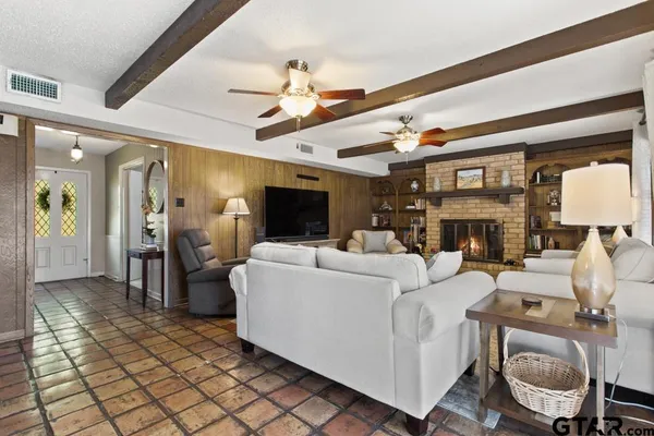 a living room with furniture a fireplace and a flat screen tv