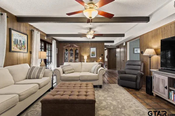 a living room with furniture ceiling fan and a rug