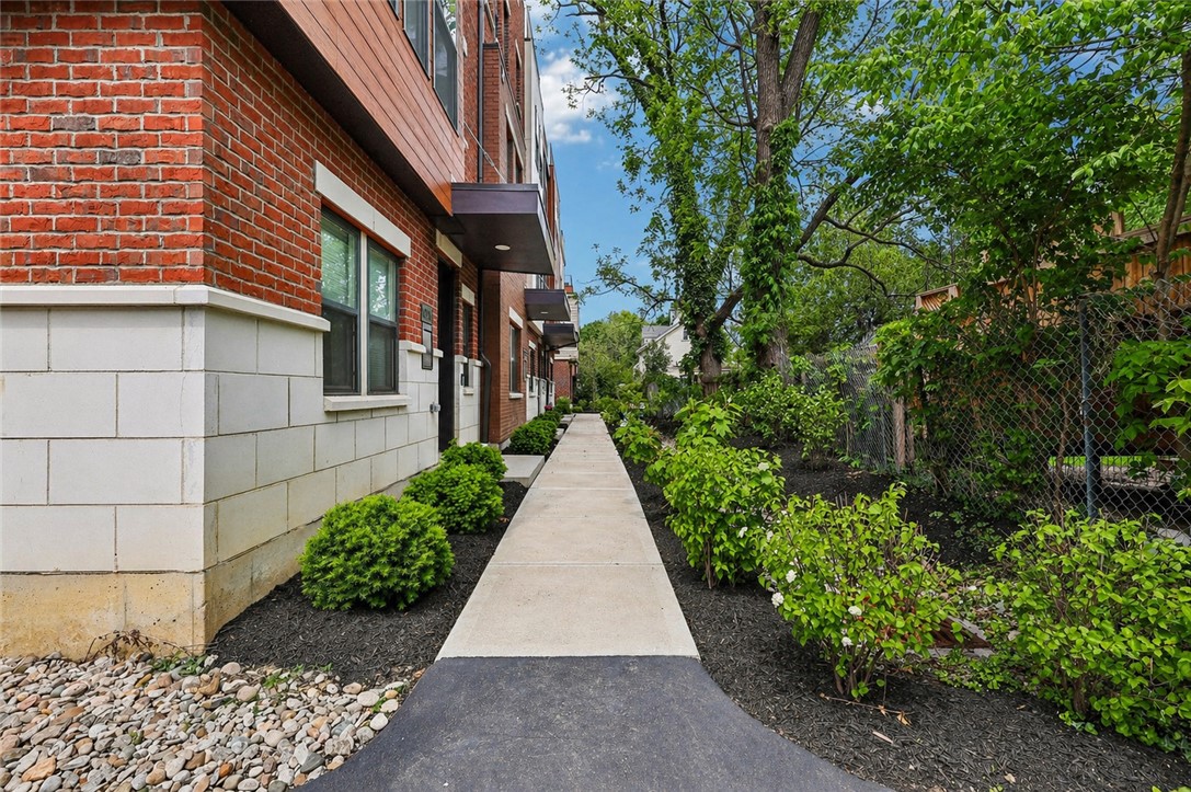 3906 Edwards Road, Unit C Cincinnati, OH 45209 - Photo 46 of 46 This charming walkway offers a welcoming approach to a classic brick facade, surrounded by lush greenery.