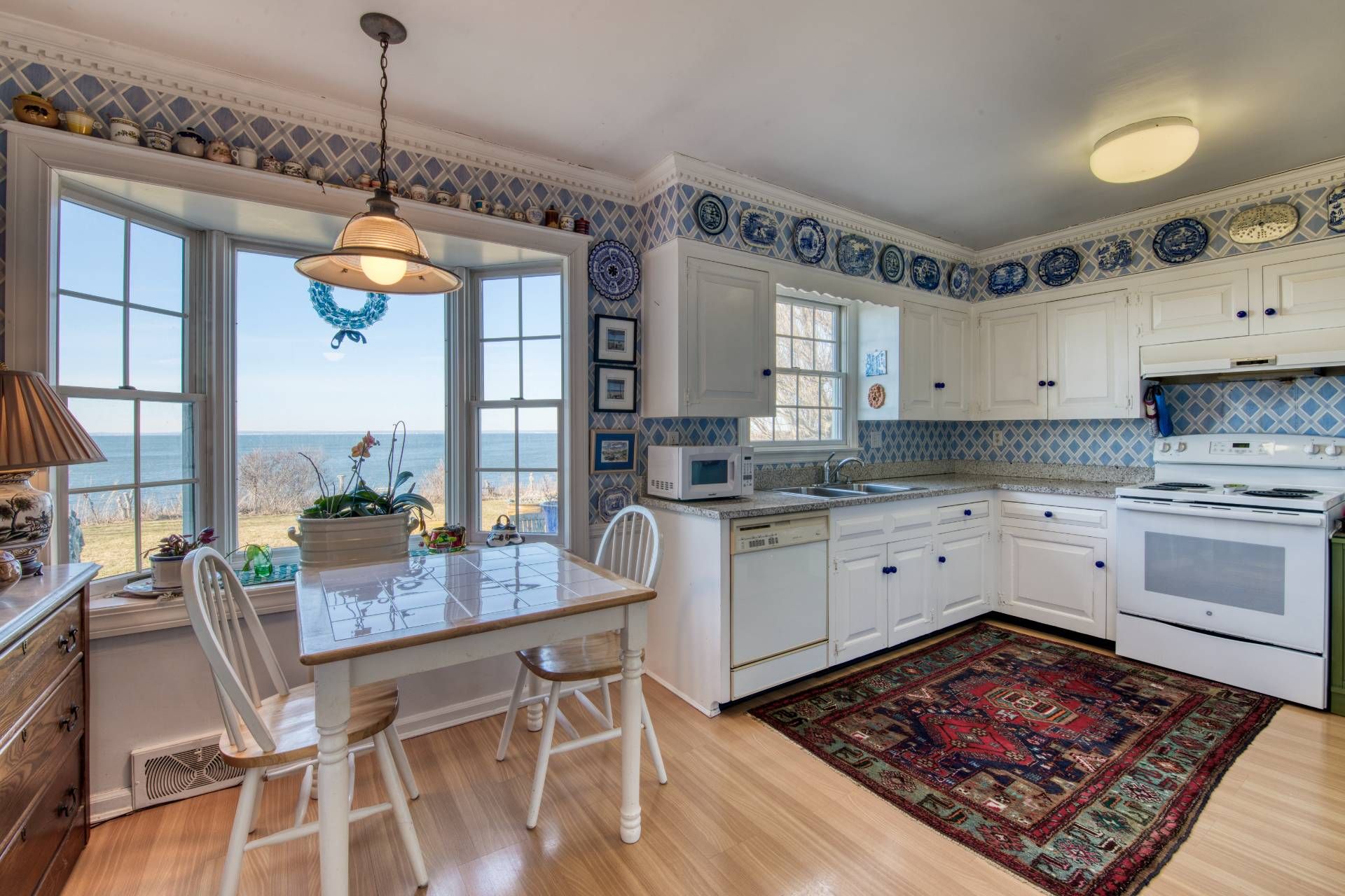 335 Sound View Road Orient, NY 11957 - Photo 16 of 22 a kitchen with a table chairs and white cabinets