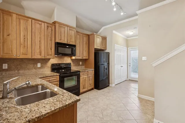 a kitchen with kitchen island granite countertop a refrigerator stove and sink