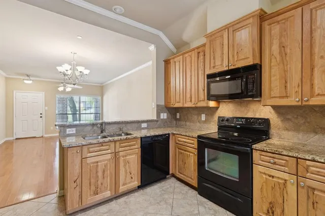 a kitchen with stainless steel appliances granite countertop a stove a sink and a microwave