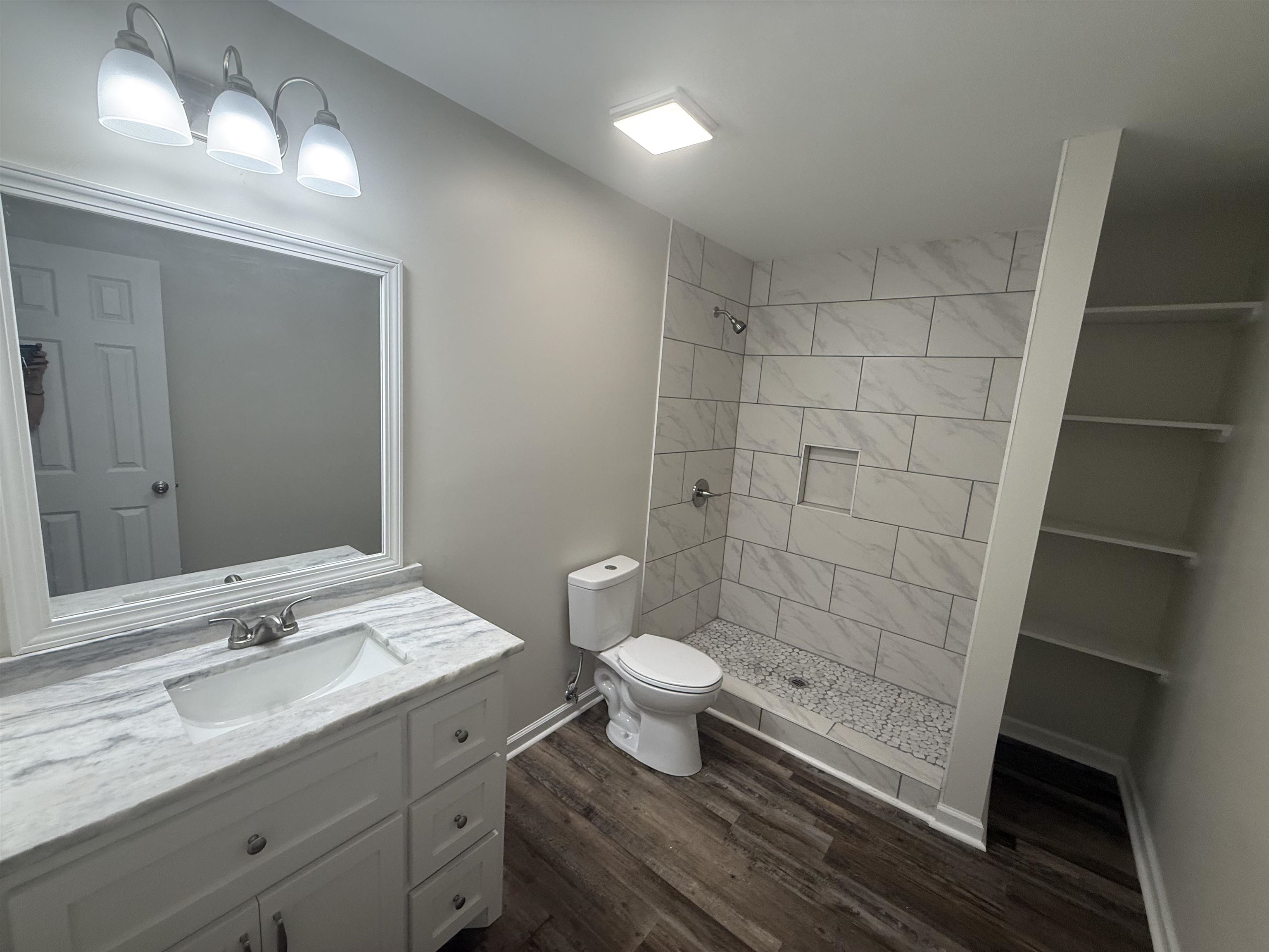 195 Poole Road Moscow, TN 38057 - Photo 10 of 21 Bathroom featuring a white vanity with an integrated sink, a marble-patterned countertop, and a framed mirror
