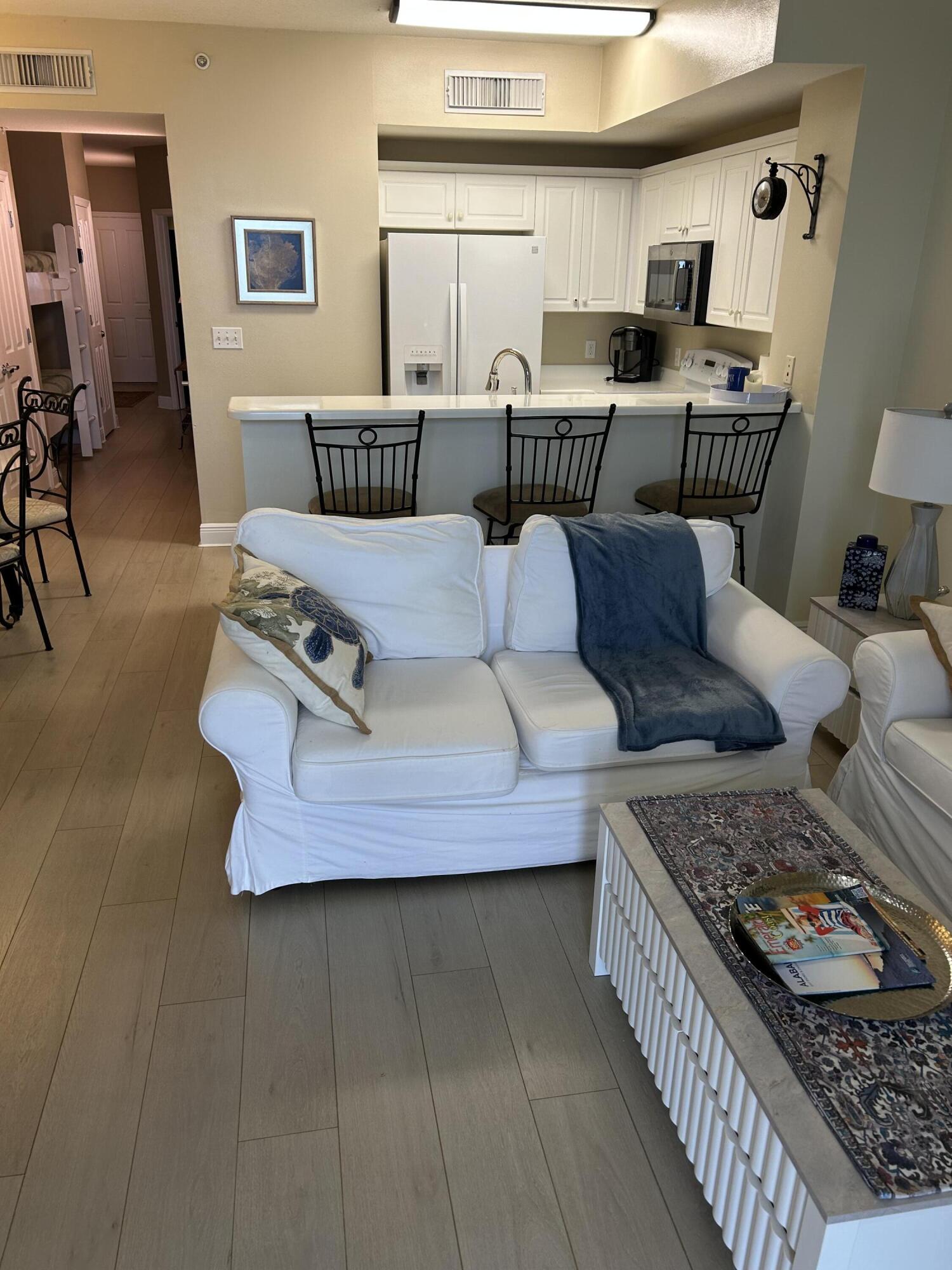 17757 Front Beach Road, Unit 2204D Panama City Beach, FL 32413 - Photo 4 of 32 a living room with furniture and wooden floor