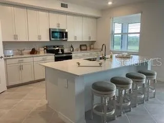 a kitchen with stainless steel appliances granite countertop a stove a sink and a white cabinets