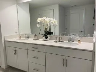 a bathroom with a sink double vanity granite and a mirror