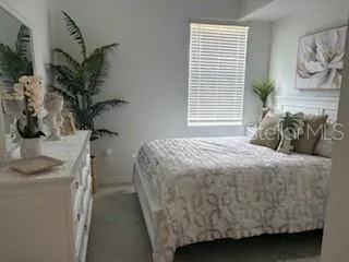 a bedroom with a bed and a potted plant