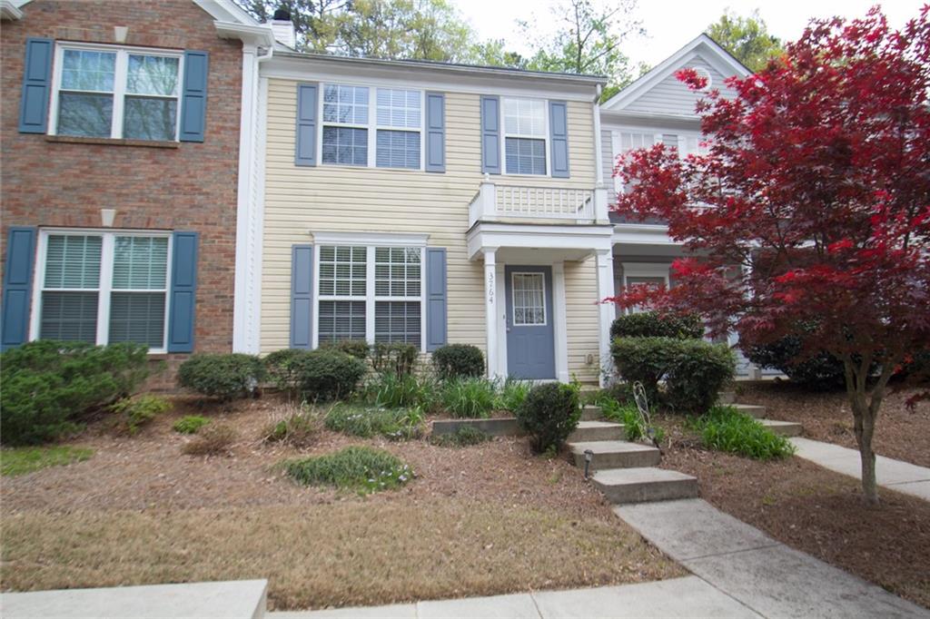 a front view of a house with garden and plants