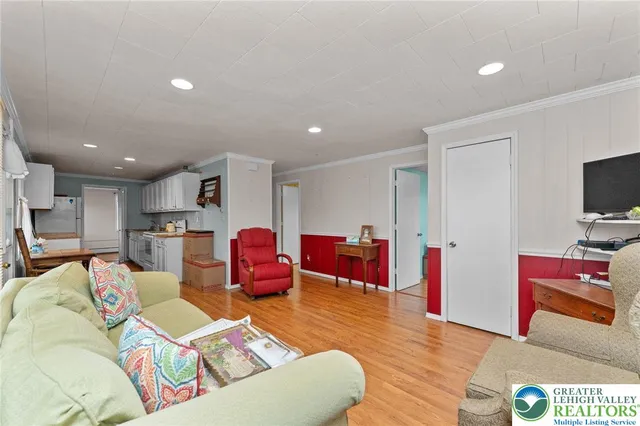 a living room with furniture kitchen view and a flat screen tv