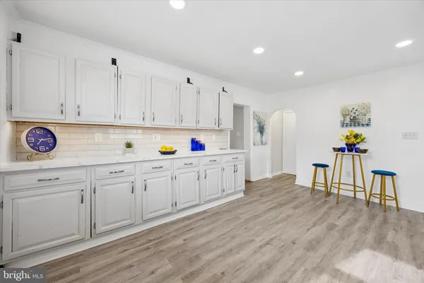 a kitchen with granite countertop a refrigerator a stove a sink cabinets and wooden floor