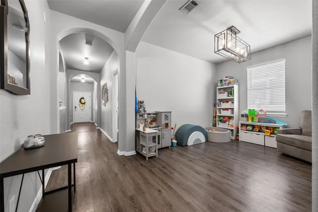 a view of a dining room with furniture a chandelier and wooden floor