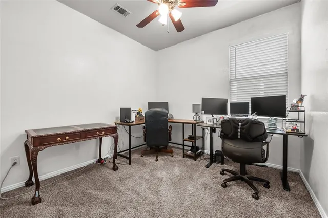 a view of a workspace with furniture and a window