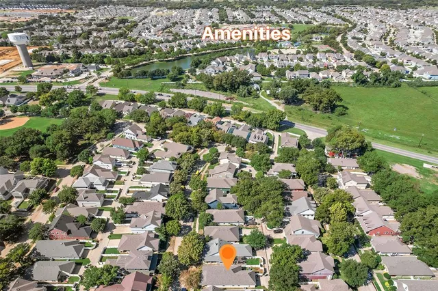 an aerial view of residential houses with outdoor space and trees