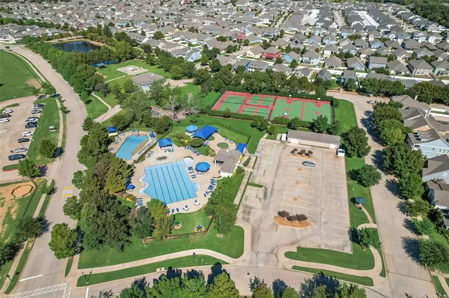 an aerial view of a swimming pool with a yard and plants