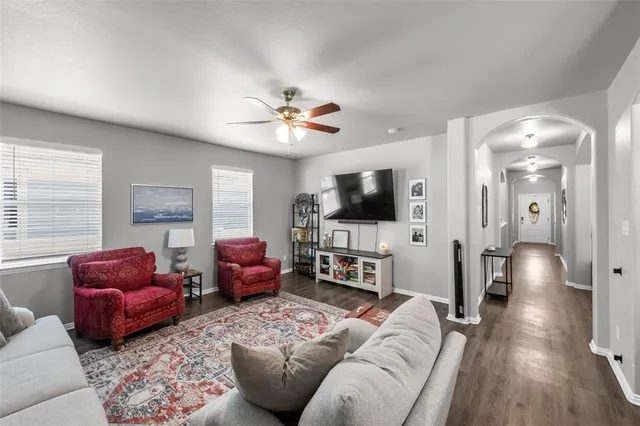 a living room with furniture a flat screen tv and kitchen view