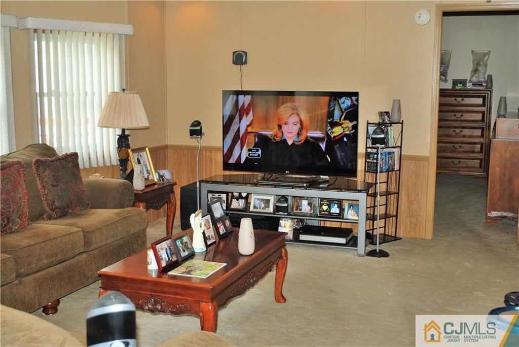 23 Poe Road, Unit 23 North Brunswick, NJ 08902 - Photo 11 of 16 a living room with furniture and a flat screen tv