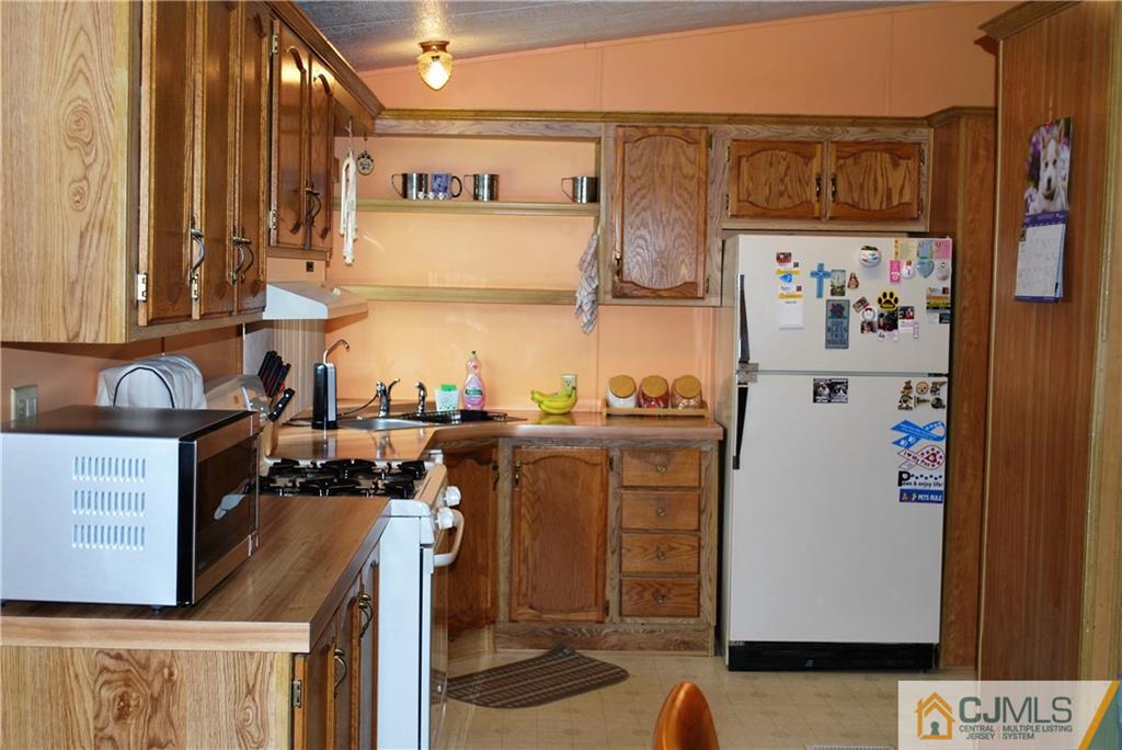 23 Poe Road, Unit 23 North Brunswick, NJ 08902 - Photo 16 of 16 a view of a kitchen with fridge and rack