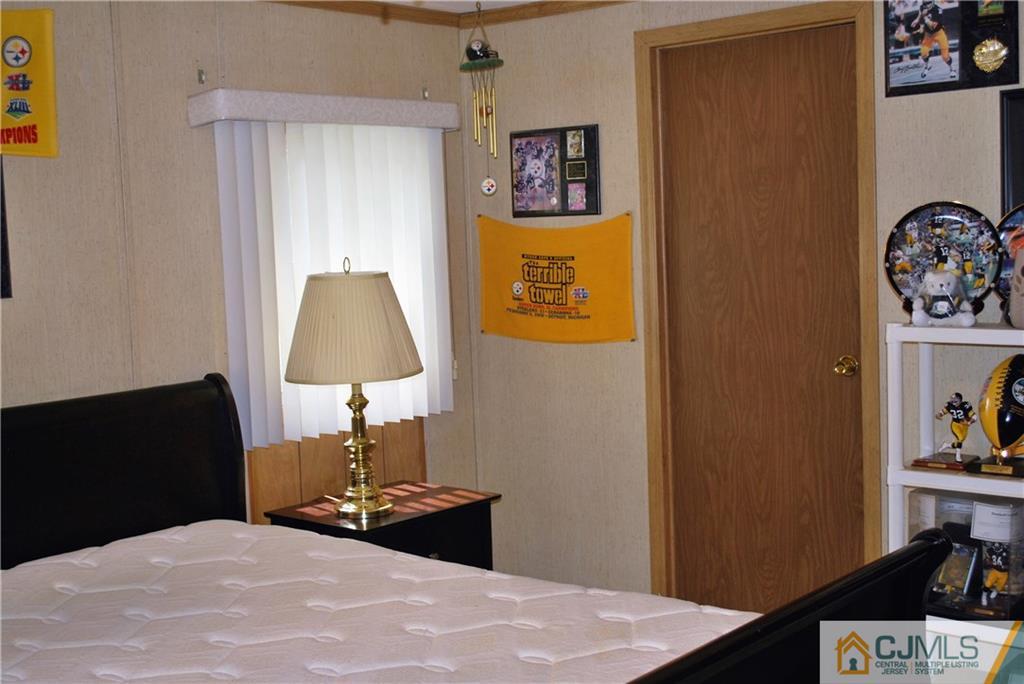 23 Poe Road, Unit 23 North Brunswick, NJ 08902 - Photo 5 of 16 a bedroom with a bed and a lamp on the table