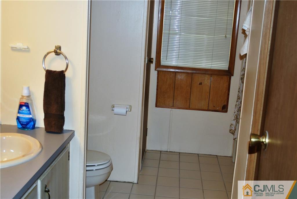 23 Poe Road, Unit 23 North Brunswick, NJ 08902 - Photo 8 of 16 a bathroom with a granite countertop sink and a mirror