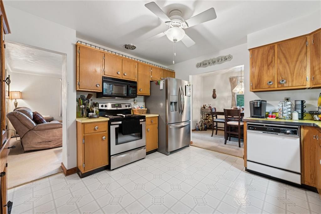 234 Ankney Hl Road Acme, PA 15610 - Photo 12 of 47 a kitchen with stainless steel appliances kitchen island granite countertop a refrigerator a stove a sink a oven with a dining table and chairs