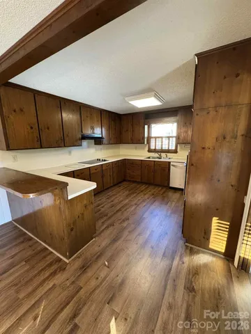 a view of a kitchen with kitchen island a sink stainless steel appliances and cabinets