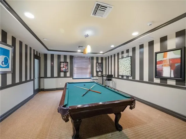 a room with furniture pool table flat screen tv and windows