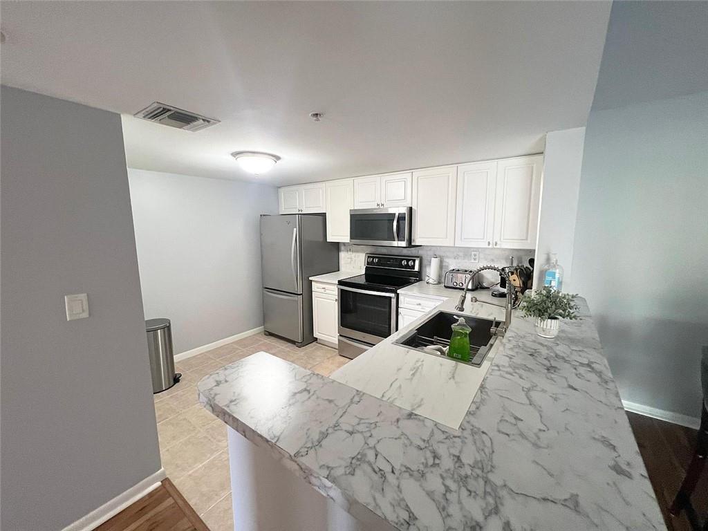 520 Southeast 5th Avenue, Unit 1502 Fort Lauderdale, FL 33301 - Photo 4 of 17 a kitchen with sink cabinets and stainless steel appliances