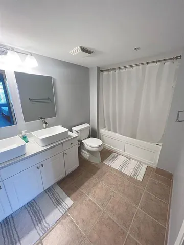 a bathroom with a double vanity sink toilet and a mirror
