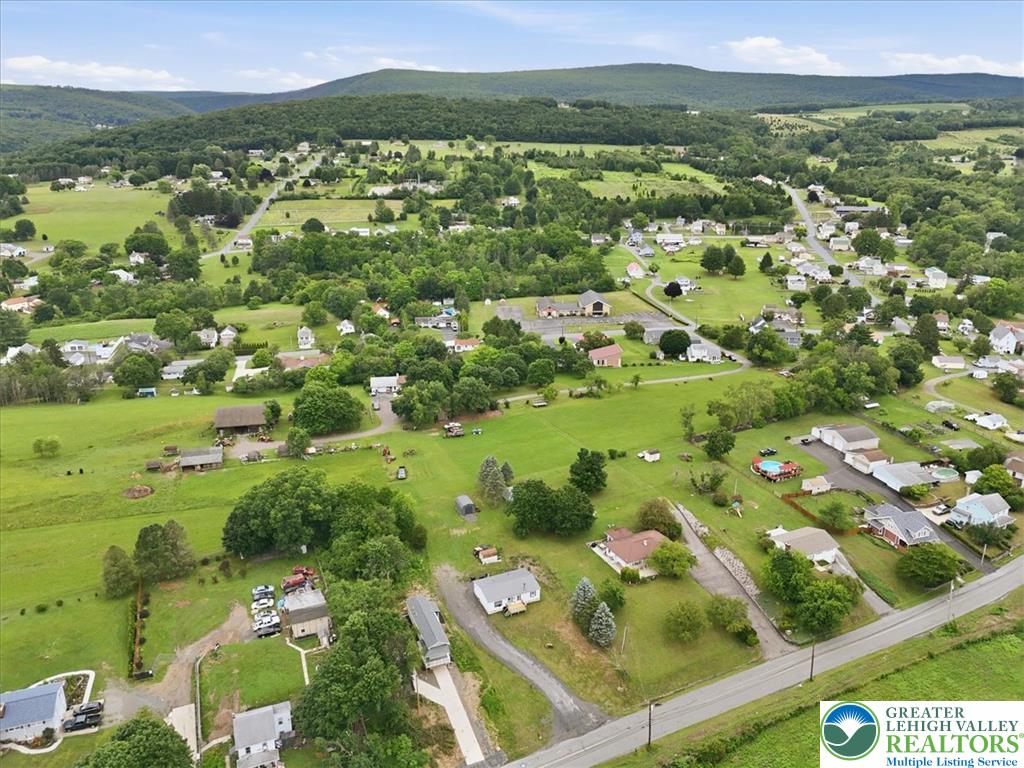 634 Main Road Lehighton, PA 18235 - Photo 35 of 39 An aerial perspective showcases a rural landscape dotted with homes and verdant hillsides.