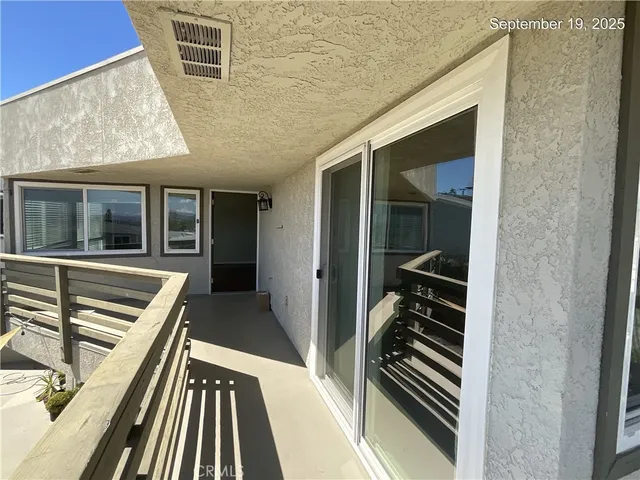 a view of a balcony with furniture and wooden floor