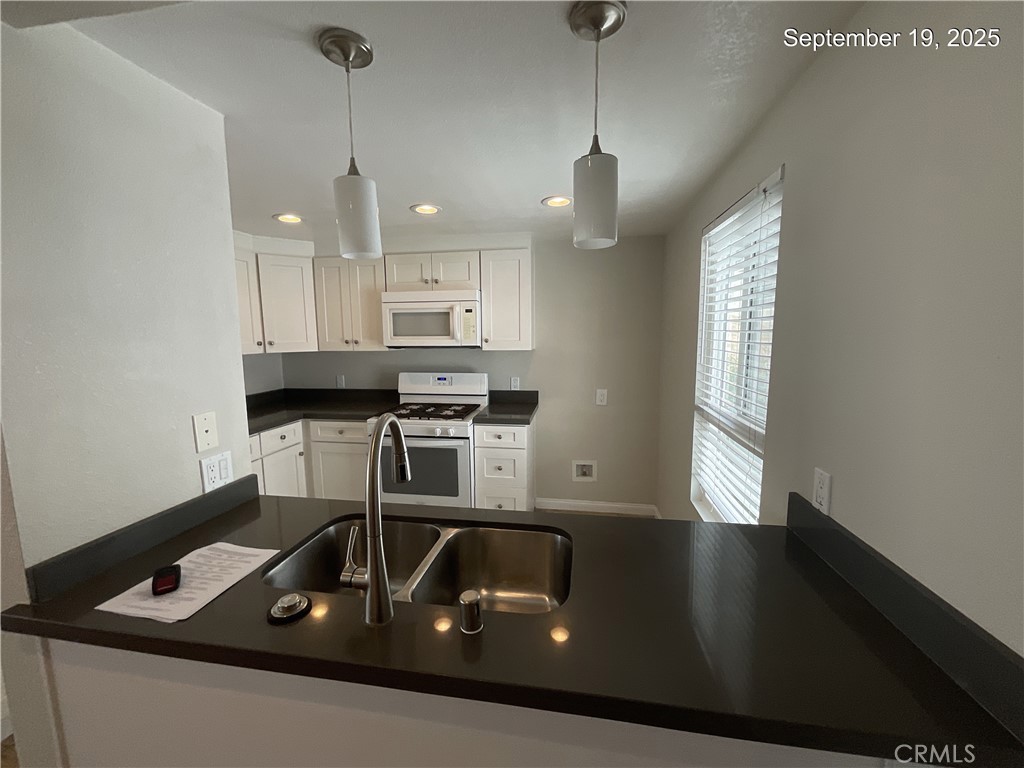 34021 Granada Drive, Unit B Dana Point, CA 92629 - Photo 3 of 23 a kitchen with kitchen island a stove a sink and a counter top space
