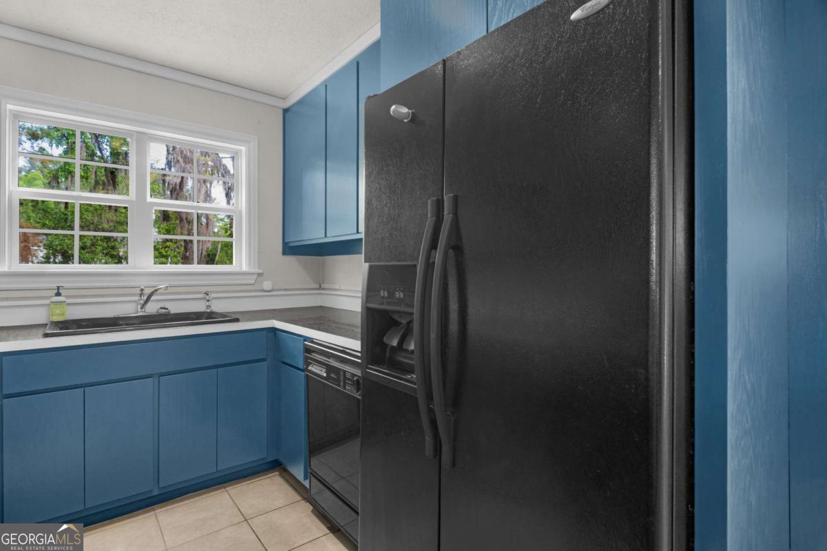 5837 Youmans Chapel Road Blackshear, GA 31516 - Photo 14 of 30 a kitchen with a sink a refrigerator and window
