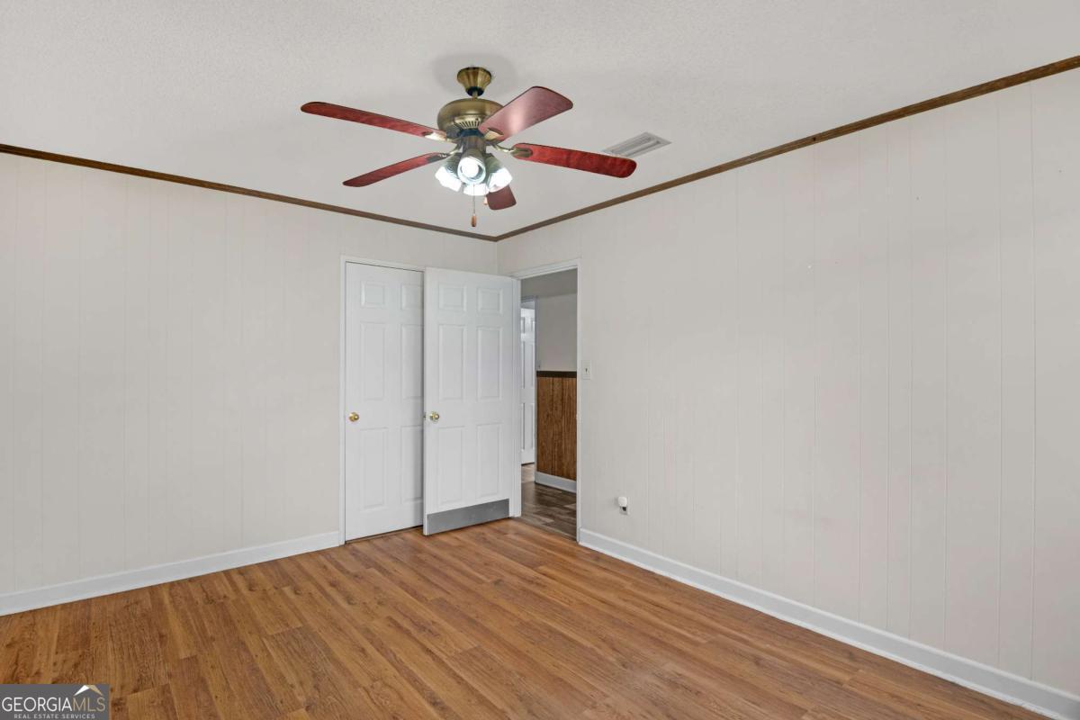 5837 Youmans Chapel Road Blackshear, GA 31516 - Photo 20 of 30 a view of a room with a ceiling fan and wooden floor