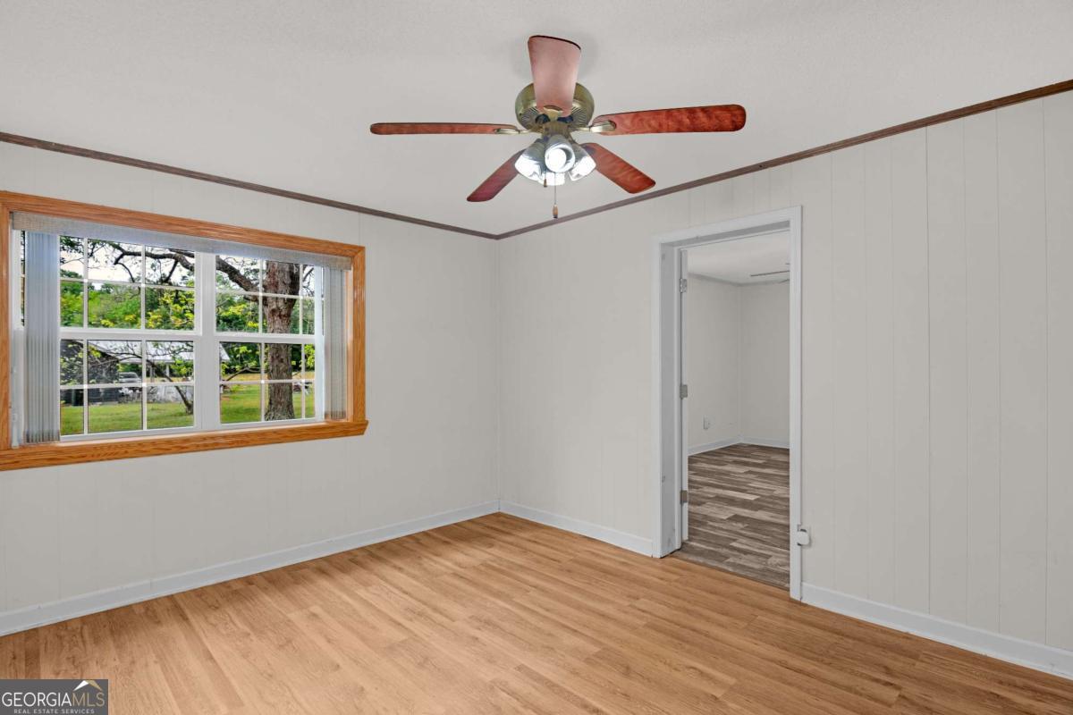 5837 Youmans Chapel Road Blackshear, GA 31516 - Photo 21 of 30 a view of an empty room with wooden floor and a window