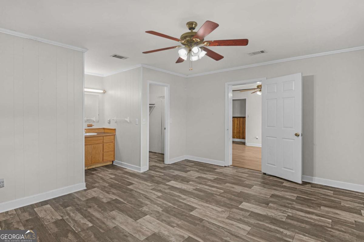 5837 Youmans Chapel Road Blackshear, GA 31516 - Photo 23 of 30 a view of empty room with wooden floor and ceiling fan