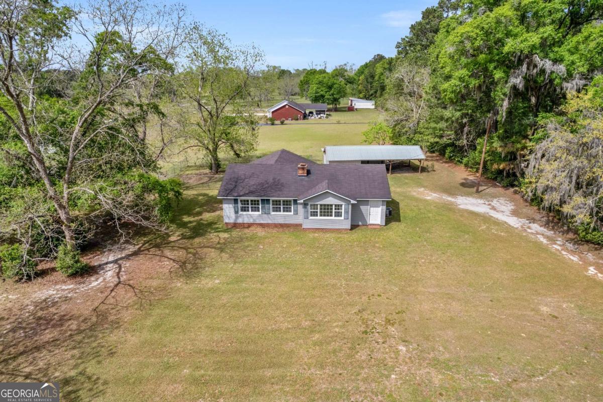 5837 Youmans Chapel Road Blackshear, GA 31516 - Photo 3 of 30 a view of a big house with a big yard and large trees