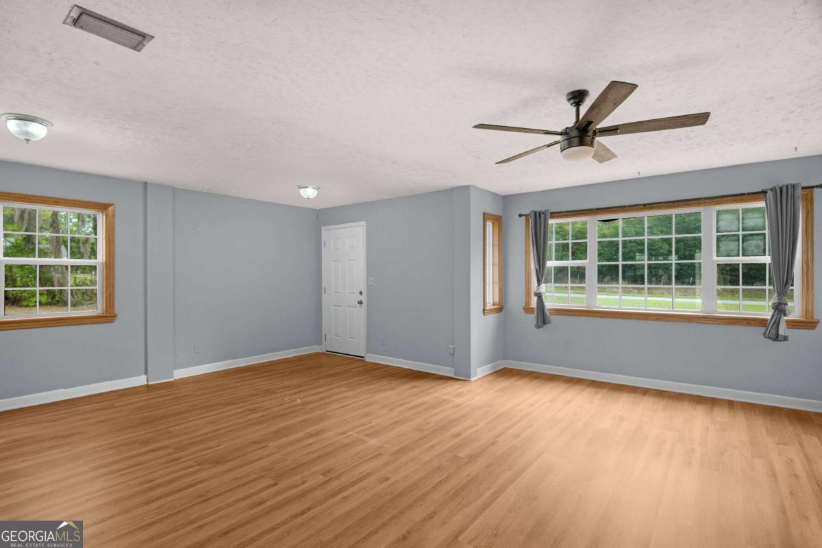 5837 Youmans Chapel Road Blackshear, GA 31516 - Photo 7 of 30 a view of an empty room with a window and wooden floor